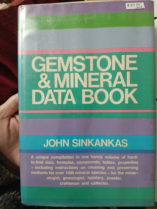 Book titled 'Gemstone & Mineral Data Book' by John Sinkankas held in a hand.